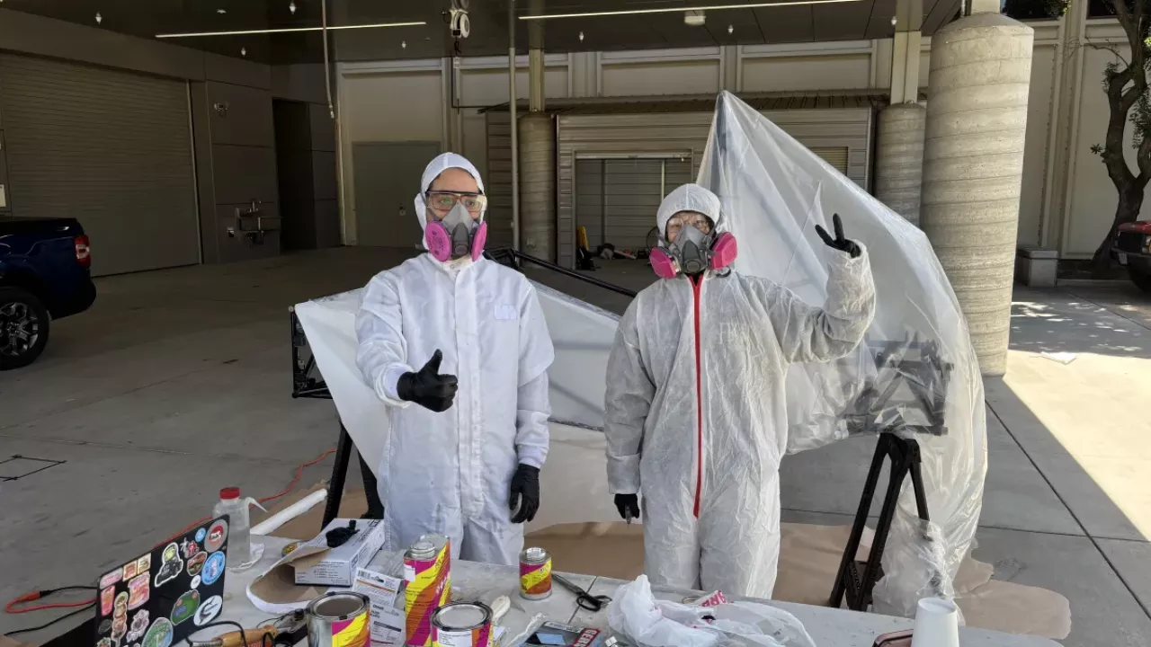 Team members pose while painting