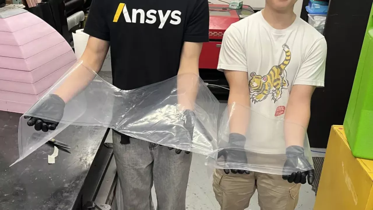 Team members holding up nosecone vacuum seal wrap