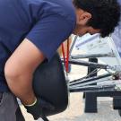 Student installing tire onto car